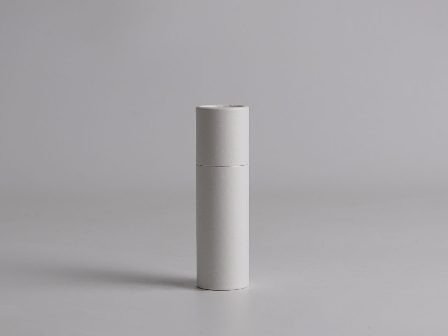 Eco-friendly white cardboard push-up tube with bottom-slide mechanism, ideal for natural lip balms, sunscreens, solid cosmetics, and skincare products.